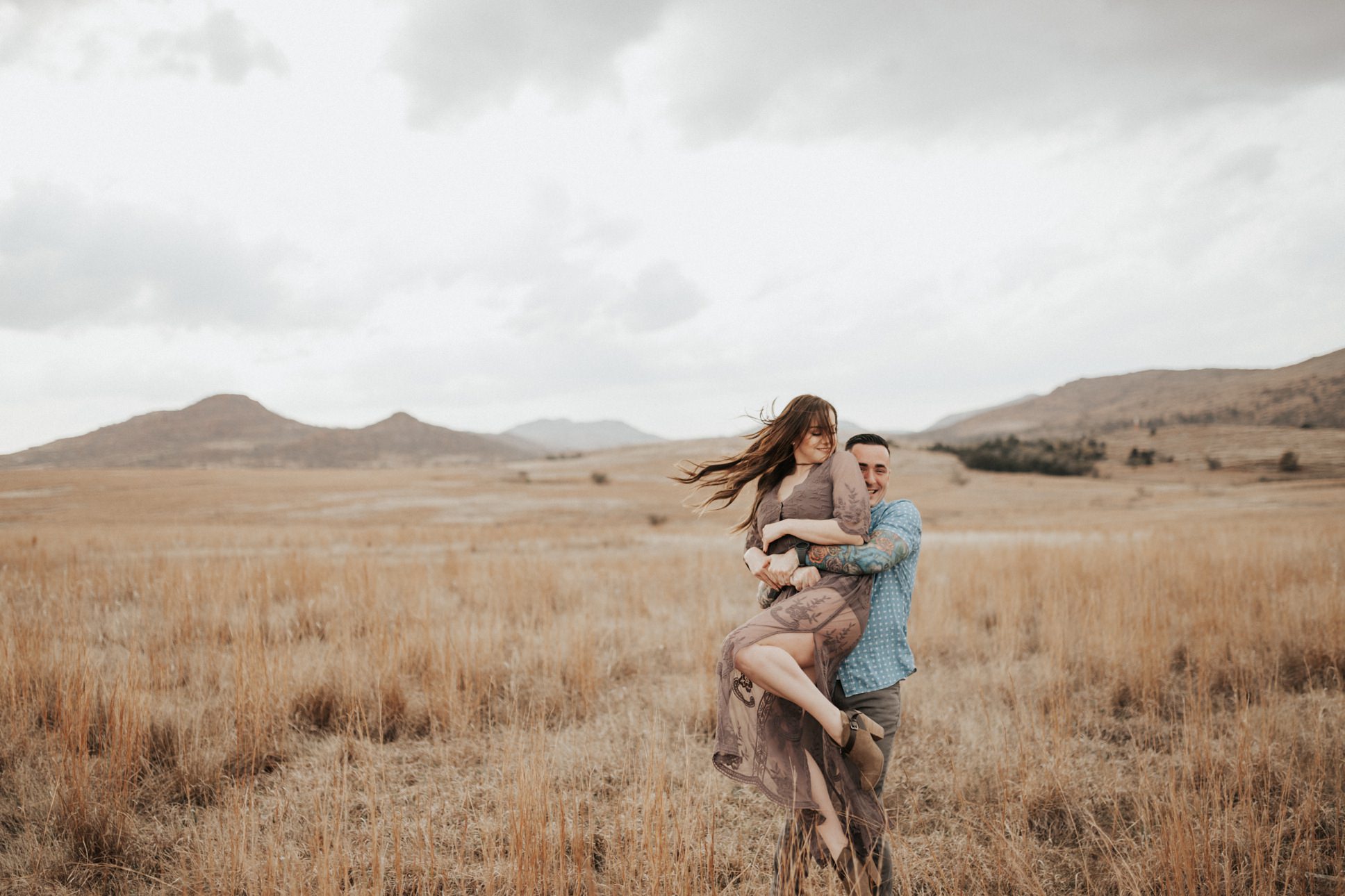 A fun photo of a couple spinning around at their Wichita Mountain Engagement Session.