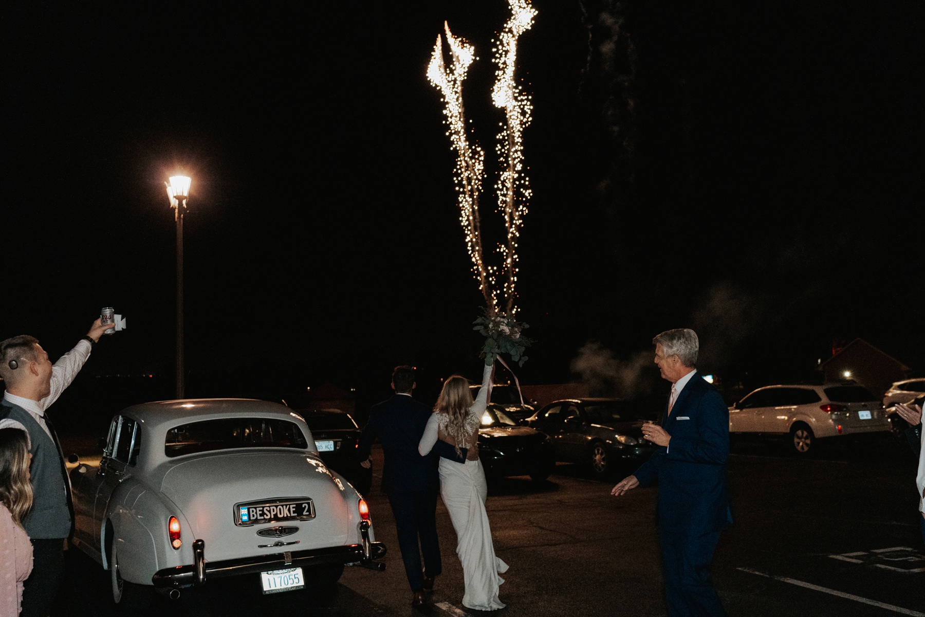 A photo of a bride and groom at their firework show exit.