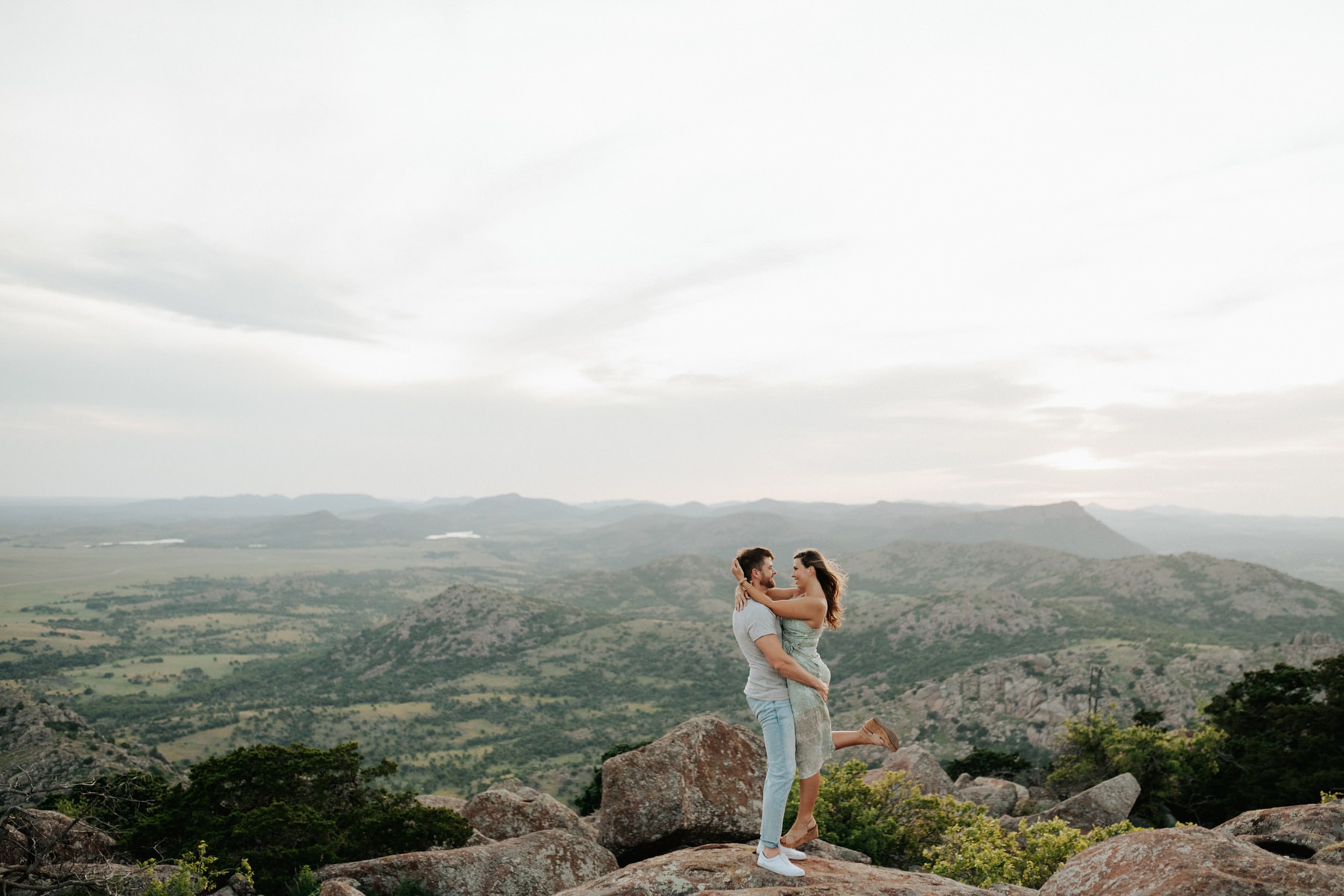 A couple embracing on a rock at their session in the Wichita Mountains.