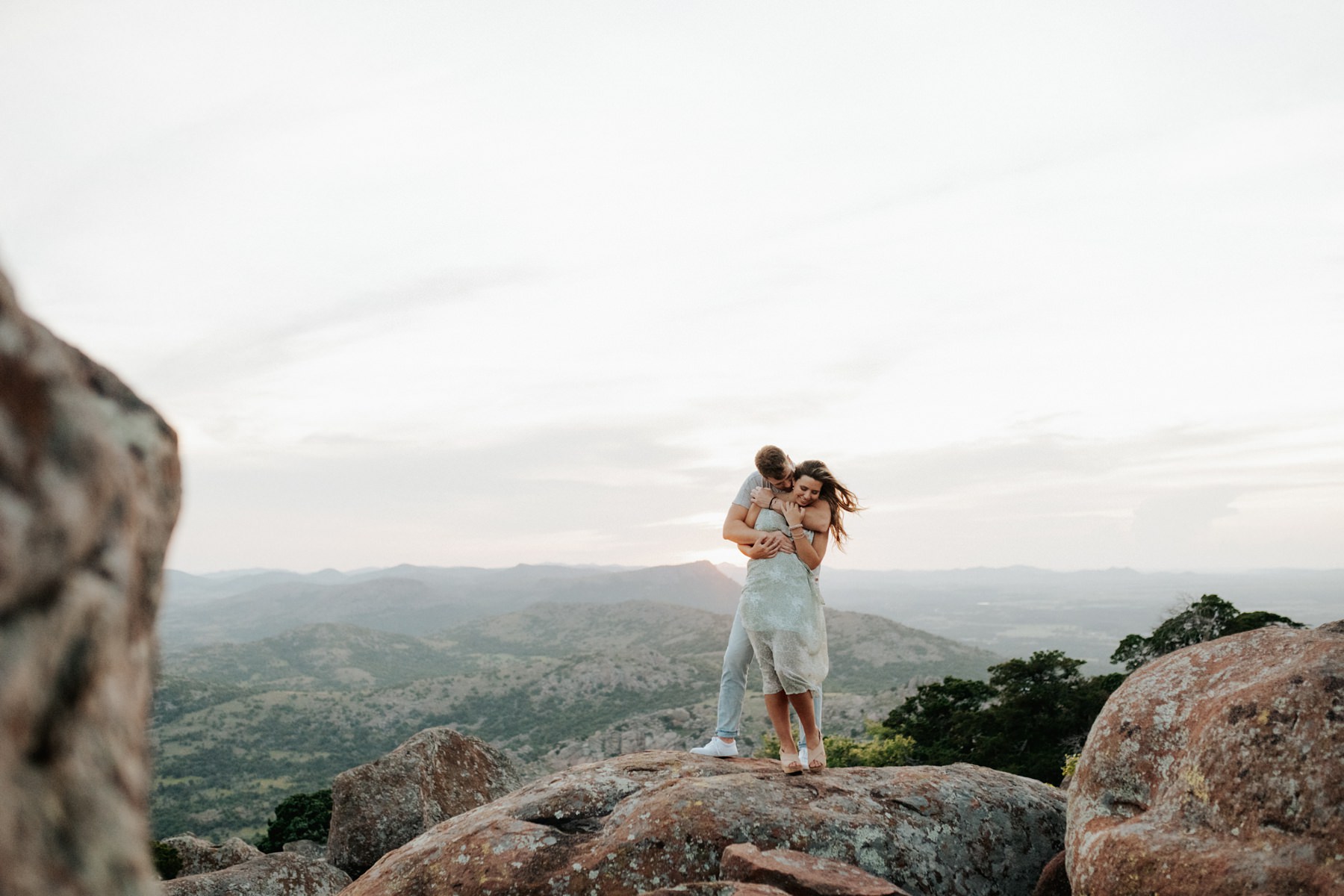 A couple embracing on a rock at their session in the Wichita Mountains.